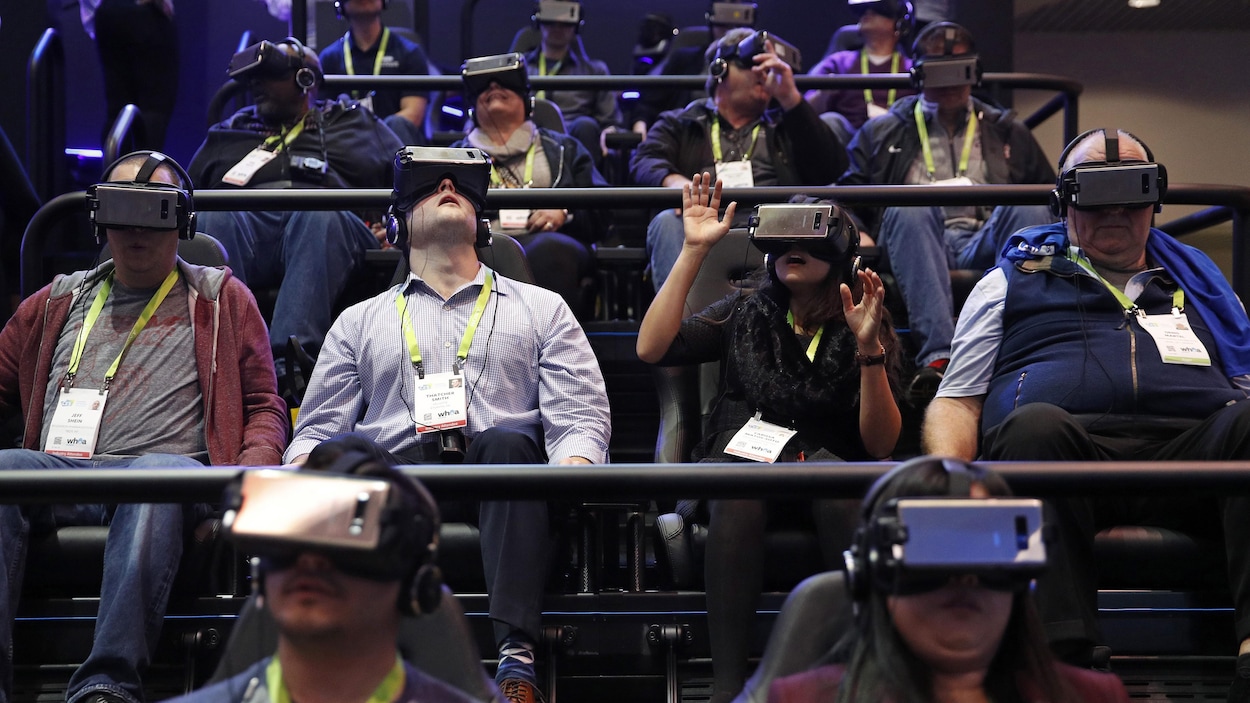Des personnes assises dans des gradins en train de réagir à une présentation en réalité virtuelle. Des personnes assises dans des gradins en train de réagir à une présentation en réalité virtuelle.