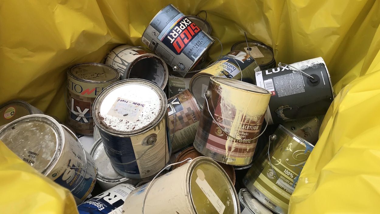 Des contenants de peinture dans un sac de plastique de couleur jaune