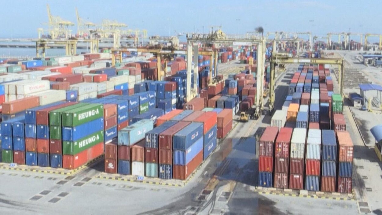 Des conteneurs empilés dans un port.