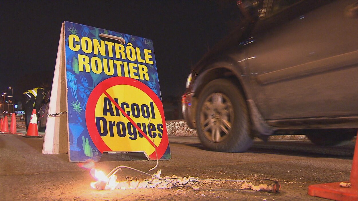Affiche posée sur le sol annonçant la présence d'un barrage policier.