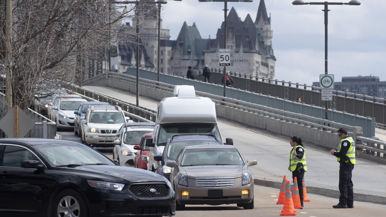 Des policiers du Service de police de Gatineau qui font un barrage à la sortie du pont Alexandra.
