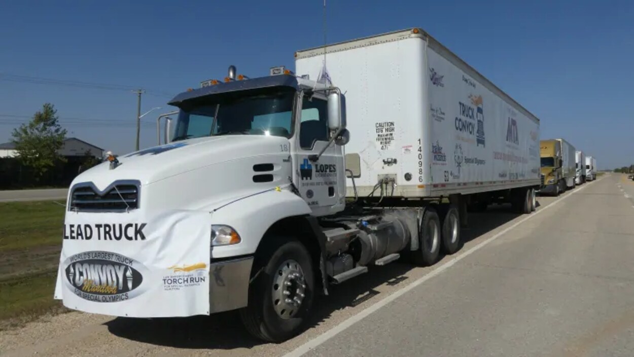 Plusieurs semi-remorques roulent à la queue leu leu sur l'autoroute périphérique de Winnipeg.