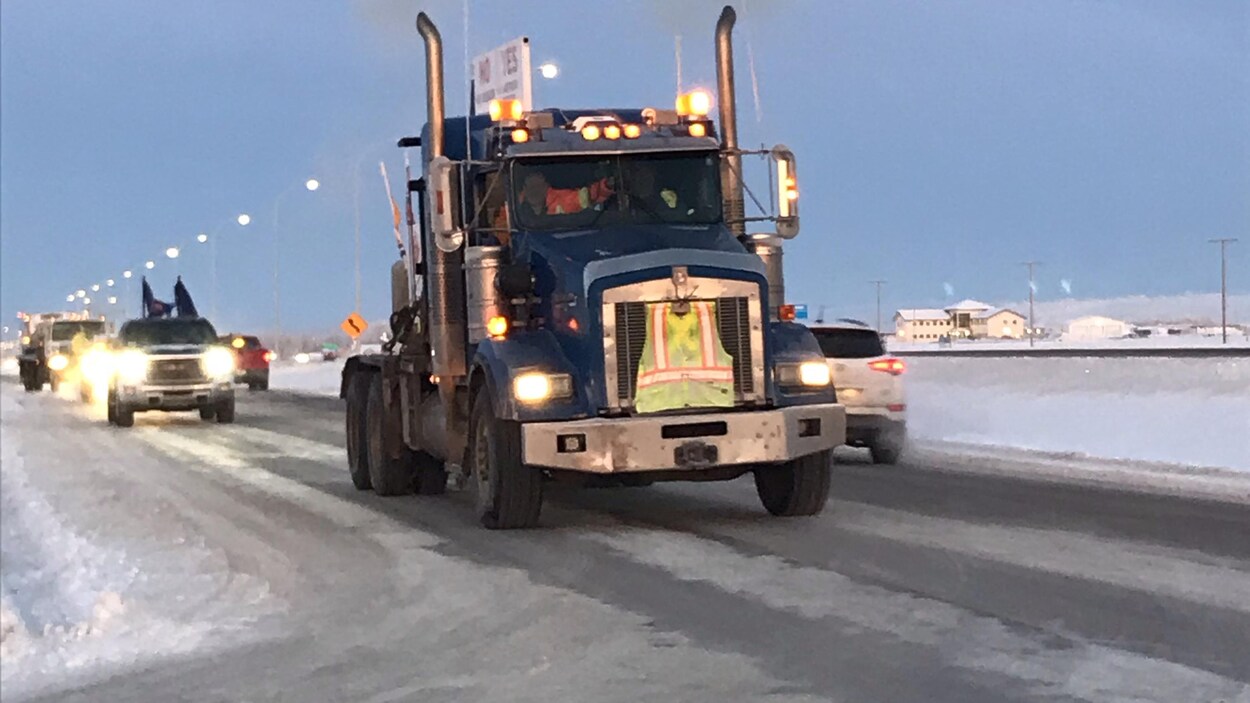 Cinq véhicules dont un semi-remorque prennent la route au petit matin.