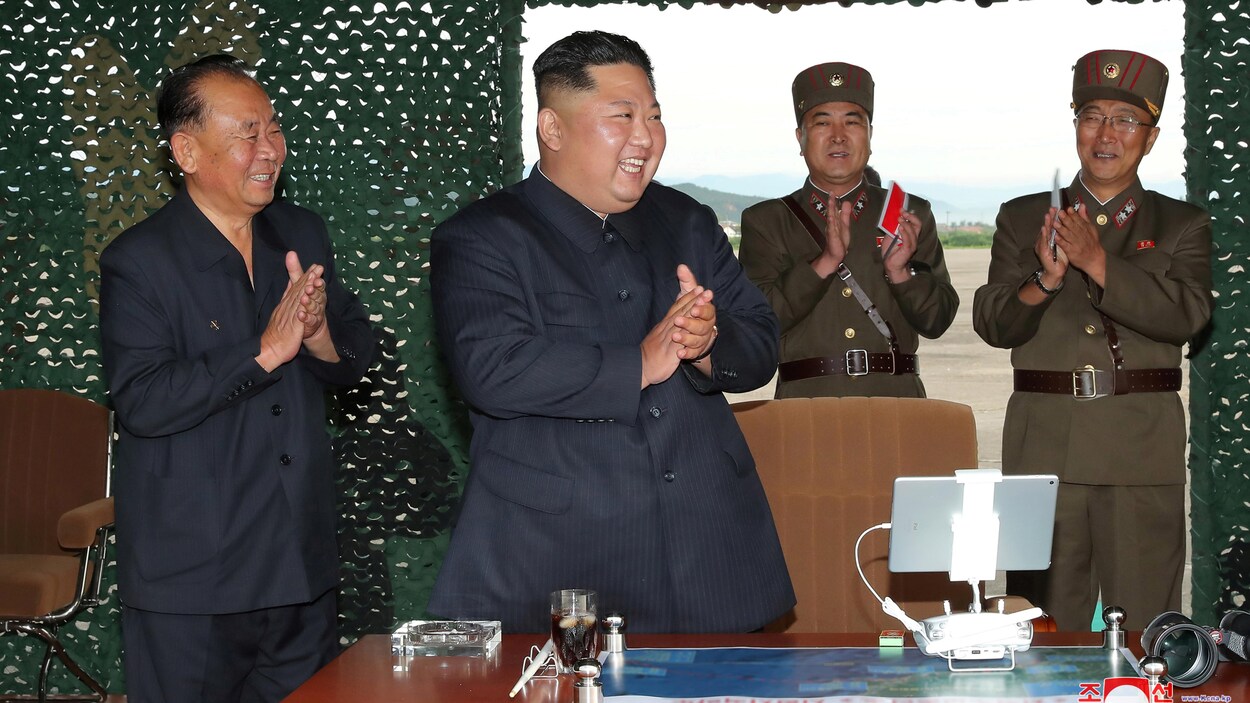 Kim Jong-un applaudi, entouré de généraux.
