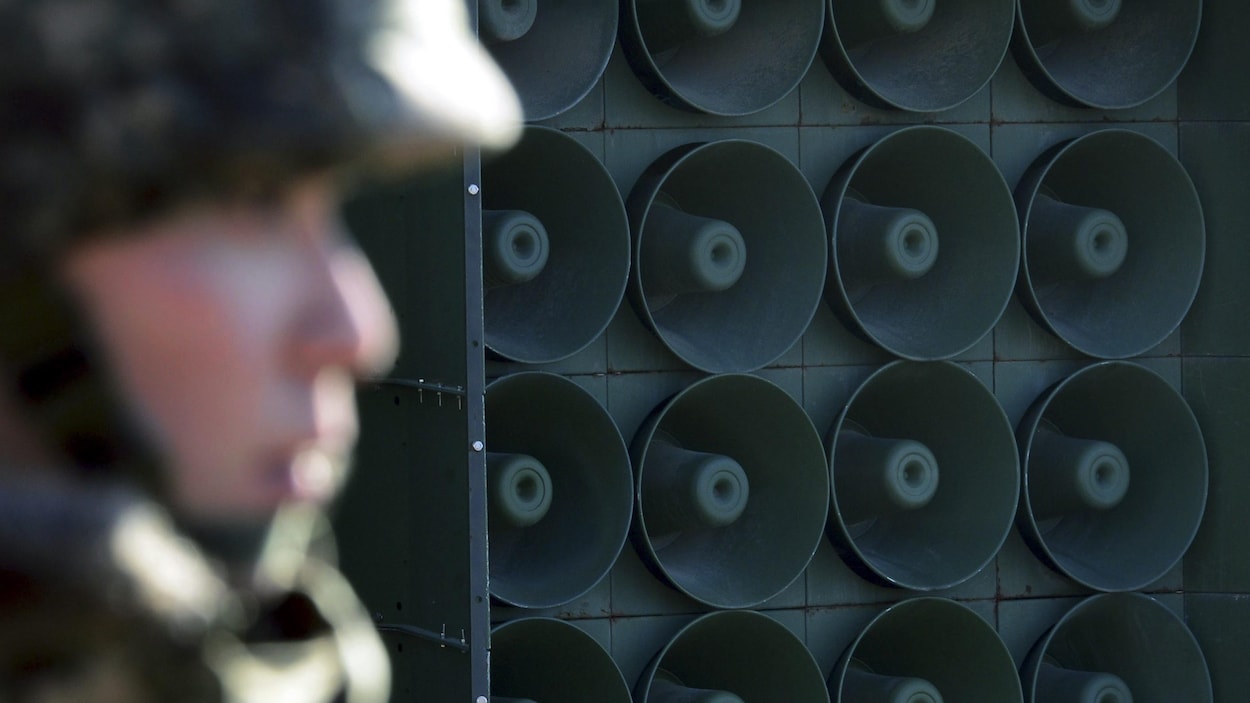 Gros plan sur un mur de haut-parleur. À l'avant-plan, un soldat sud-coréen de profil. Gros plan sur un mur de haut-parleur. À l'avant-plan, un soldat sud-coréen de profil.