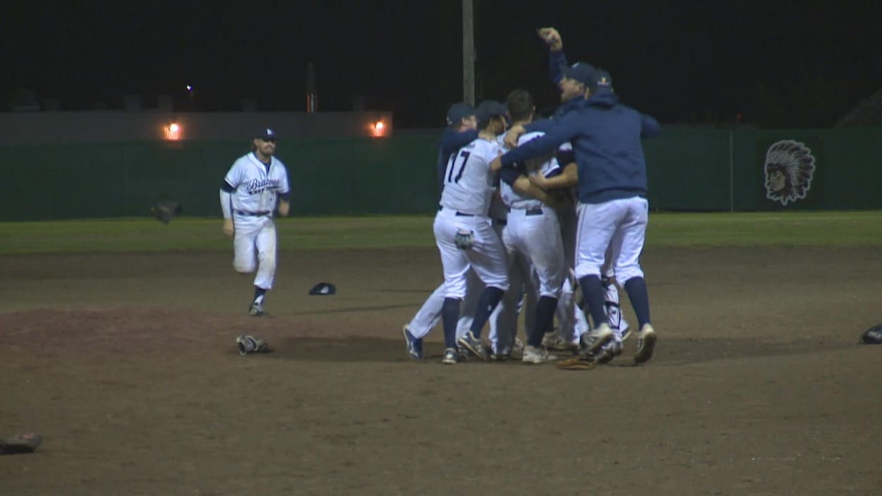 Des joueurs de baseball s'enlacent sur le terrain.