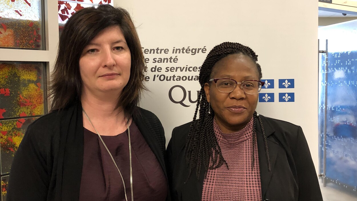 Les deux femmes posent pour une photo devant le logo du CISSS.
