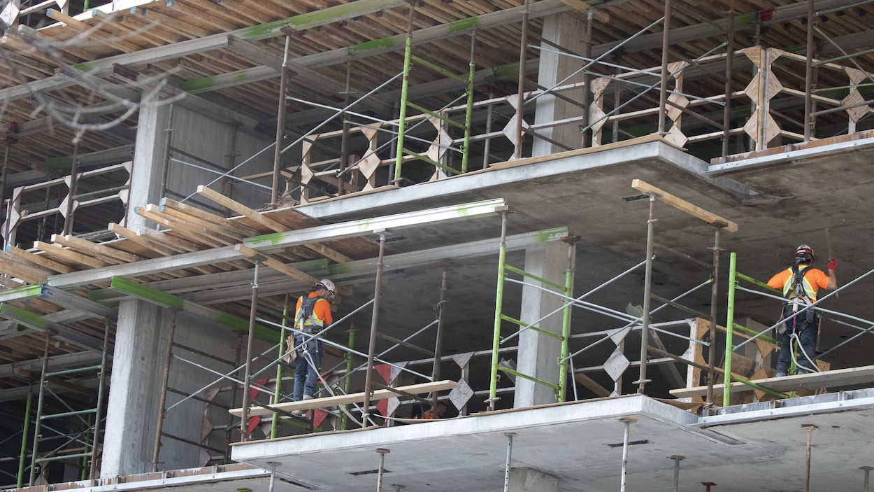 Deux ouvriers travaillent sur un chantier de construction.