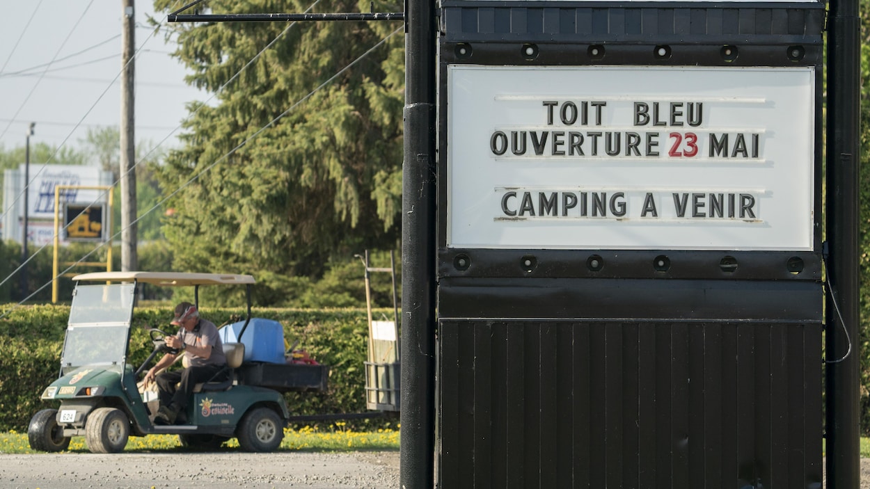 Une homme dans une voiturette sur un terrain de camping.