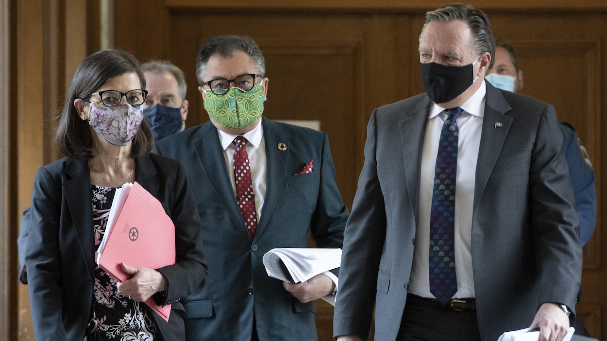 François Legault, Danielle McCann et le Dr Horacio Arruda marchent, masqués, dans un couloir de l'Assemblée nationale.