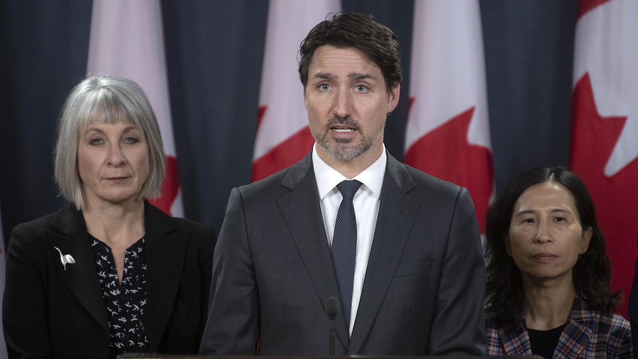 Au centre, se tient Justin Trudeau. À gauche, la ministre de la Santé, Patty Hajdu, et à droite, l'administratrice en chef de la santé publique du Canada, la Dre Theresa Tam.