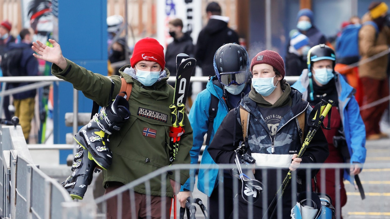 Des skieurs portent des masques et leur équipement de ski.