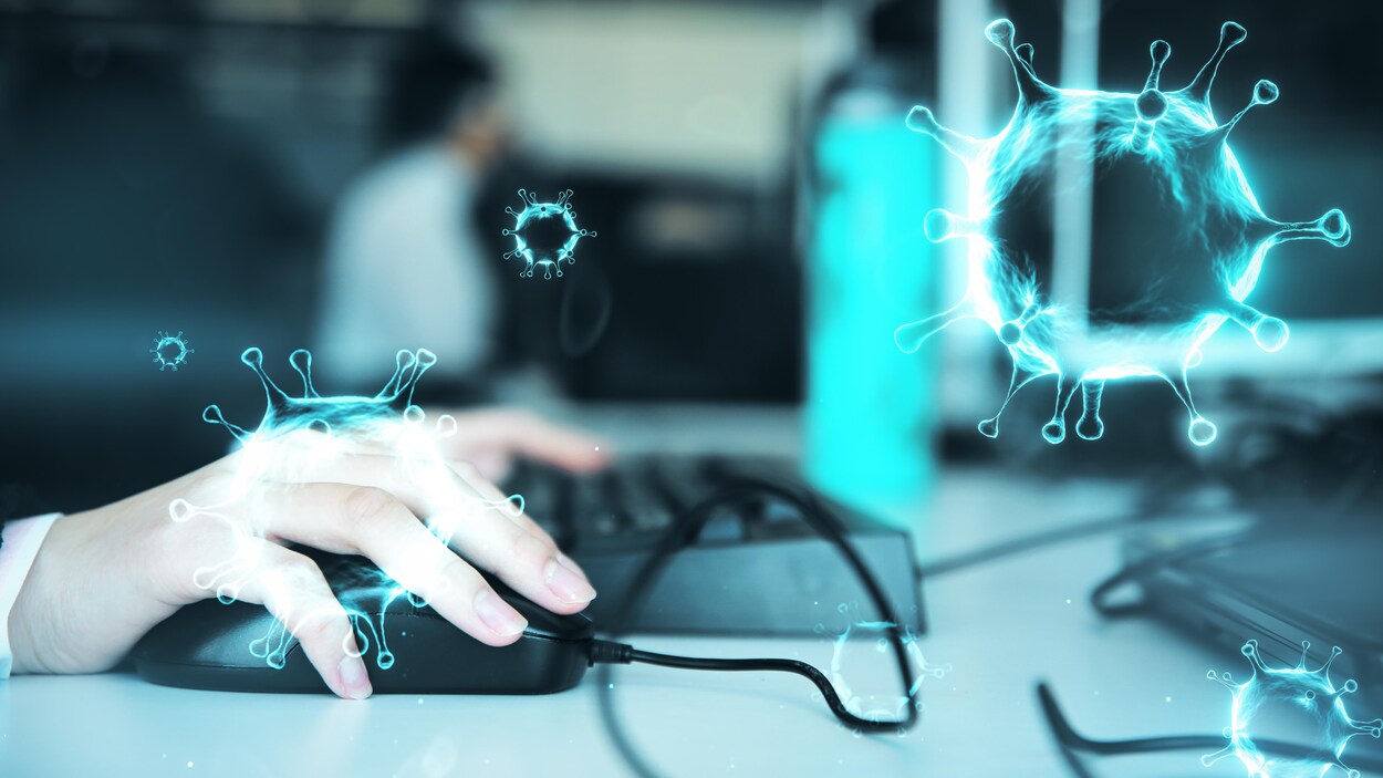 Montage photo d'une main sur une souris d'ordinateur. En filigrane, des virus.