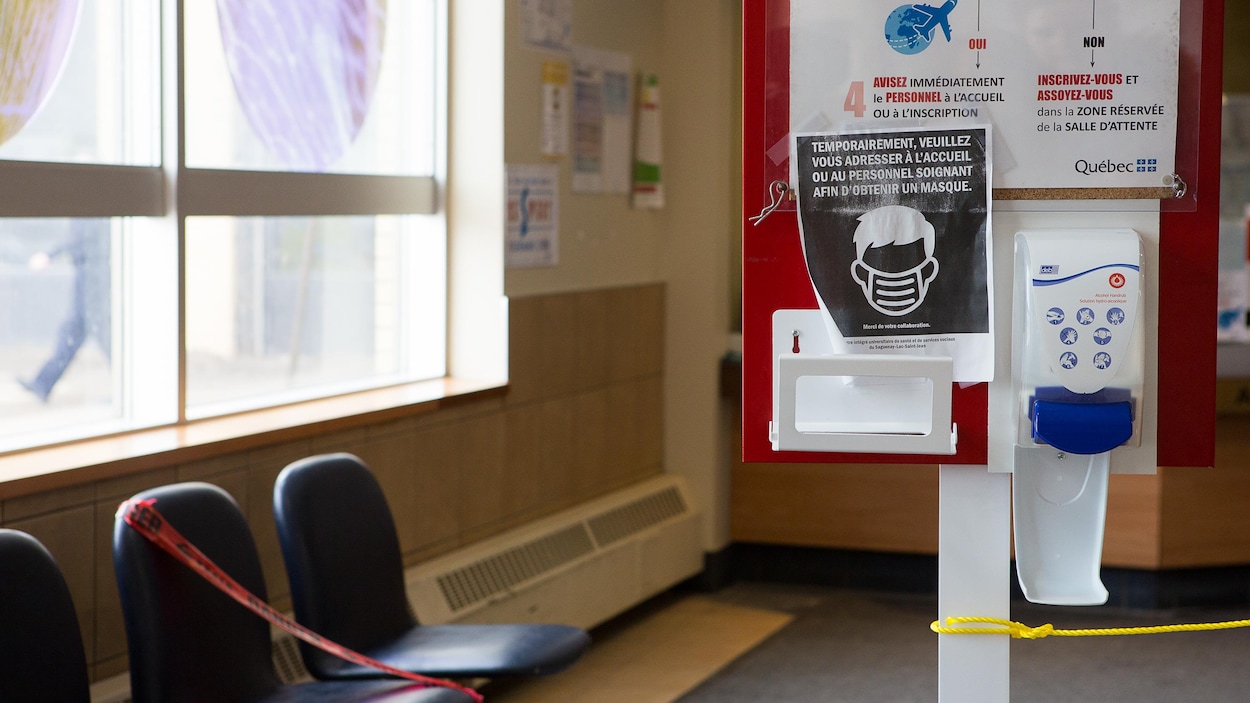 Un distributeur de désinfectant pour les mains et des consignes sur un tableau accueillent les visiteurs.