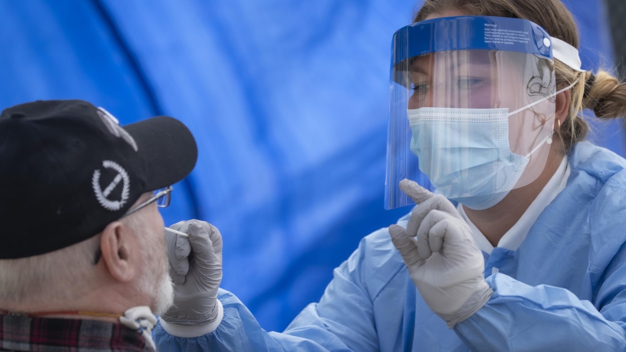 Une professionnelle de la santé effectue un test de dépistage de la COVID-19 sur un patient.