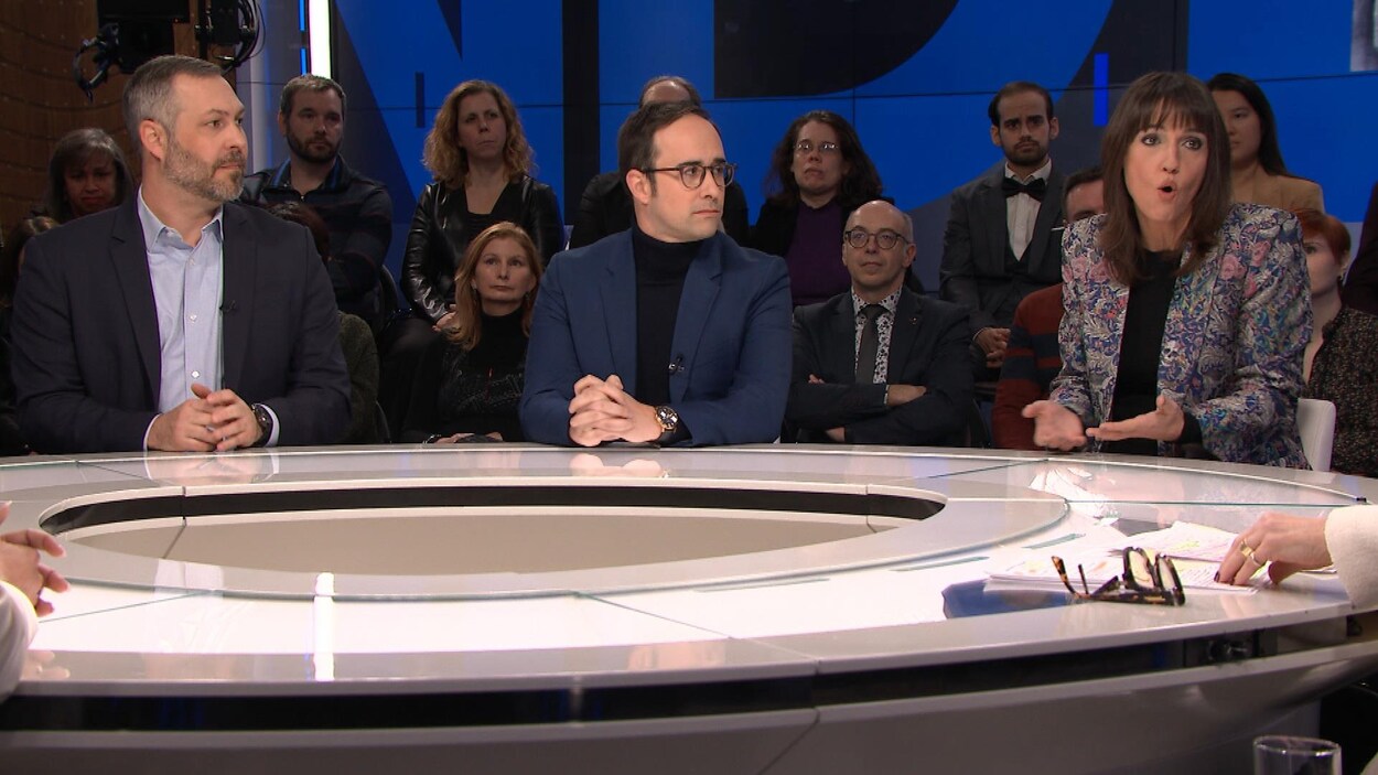 Philippe Leblanc et Raphaël Bouvier-Auclair, assis, regardent Marie-Eve Bédard répondre à une question.