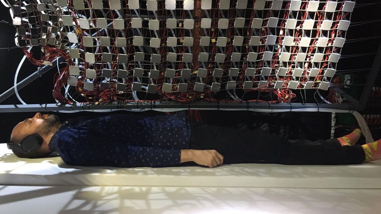 Un homme est couché sur un matelas avec des écouteurs Un homme est couché sur un matelas avec des écouteurs