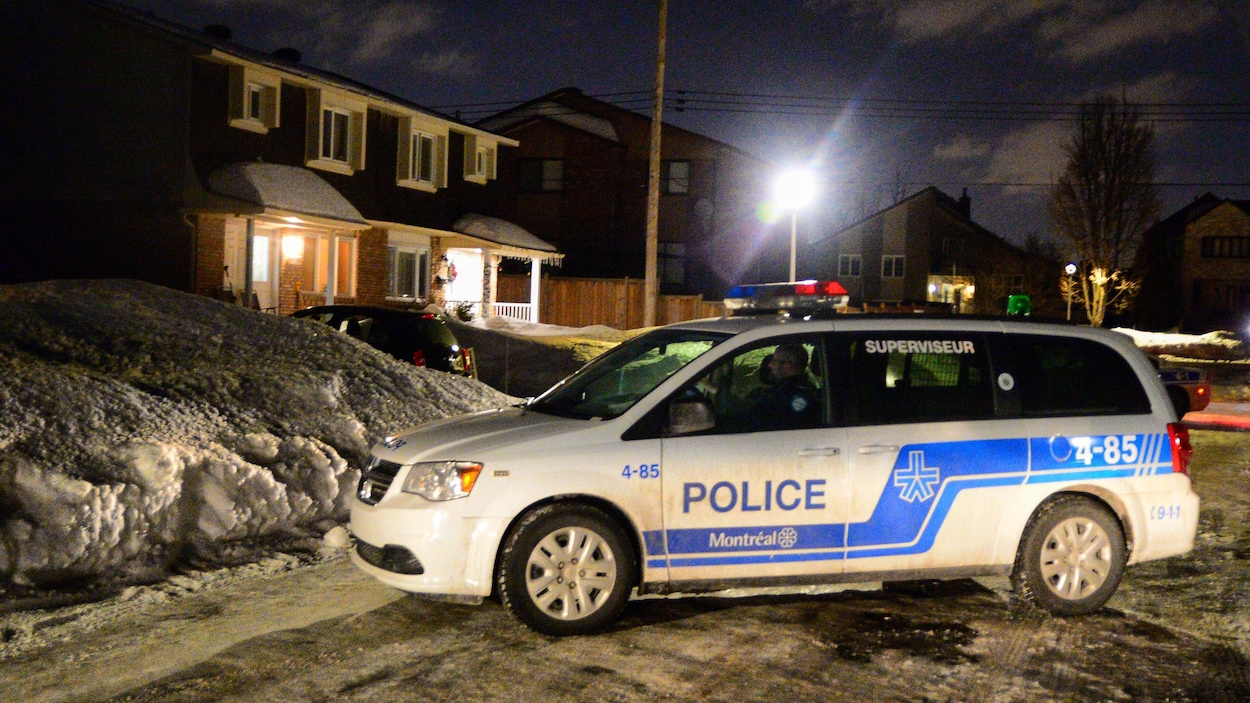 Une voiture du SPVM arrêtée dans une rue enneigée.