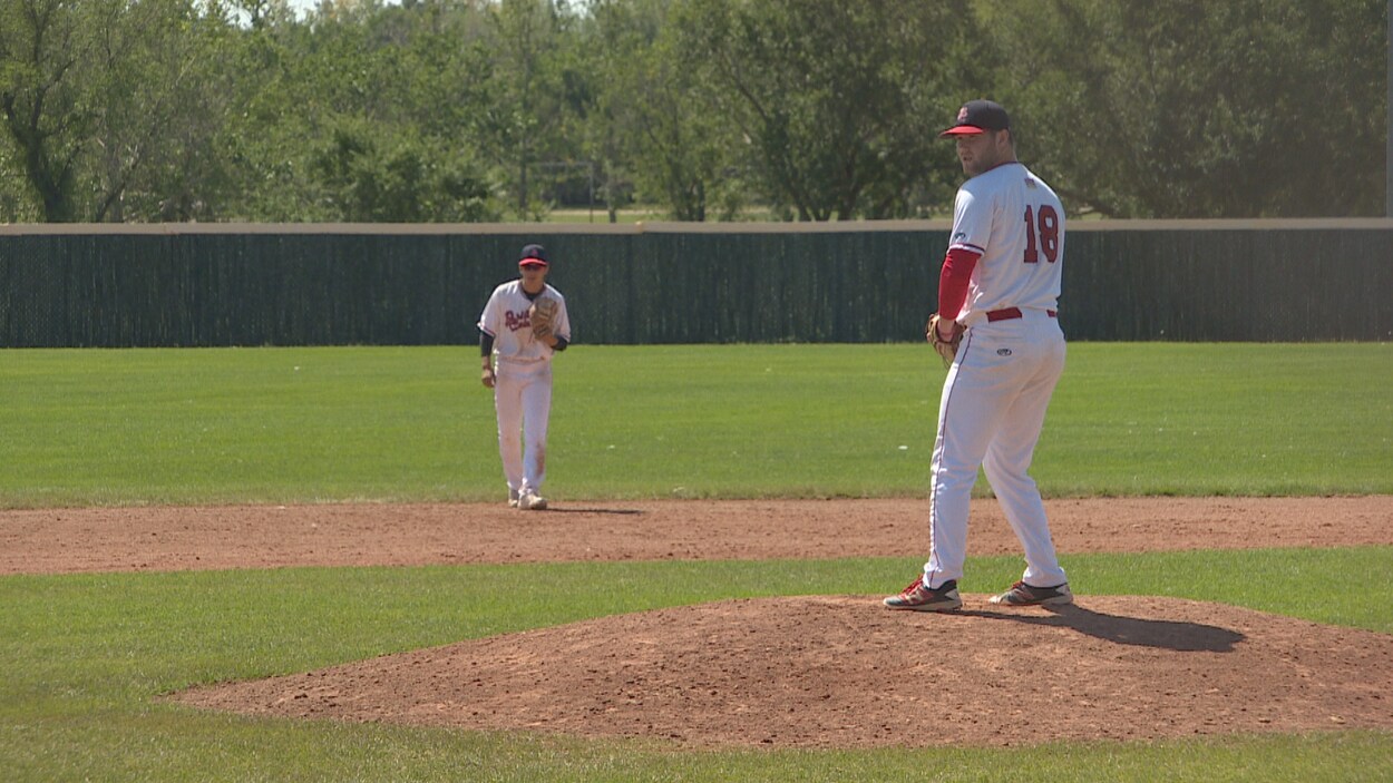 Un joueur de baseball s'apprête à lancer la balle.