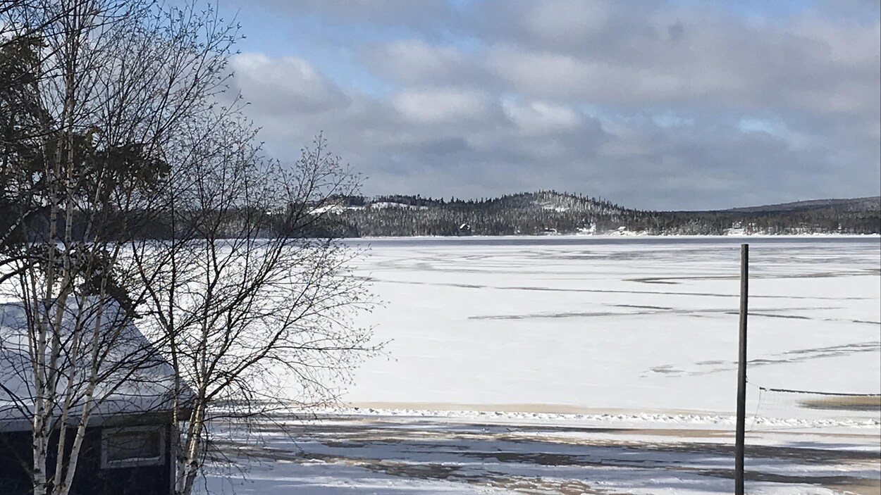 Un lac gelé avec en arrière-plan une montagne enneigée.