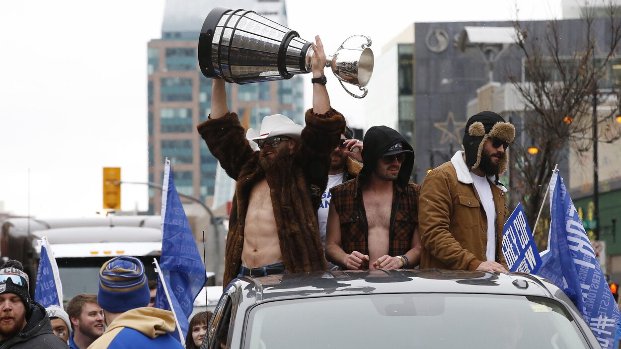 Des joueurs tiennent la coupe Grey dans leurs mains.