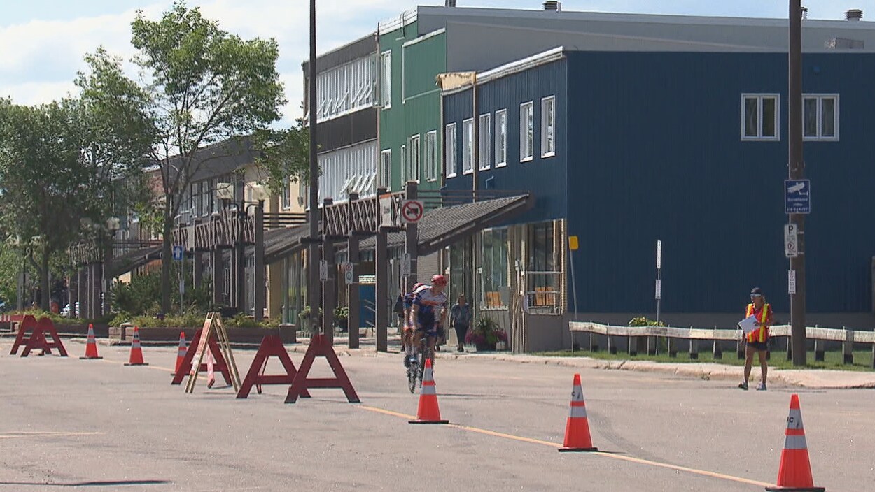 Un cycliste devant des commerces