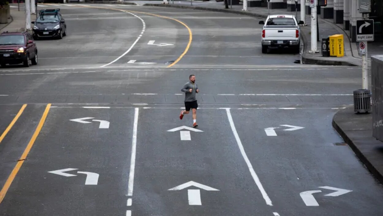Un homme traverse une rue presque déserte.