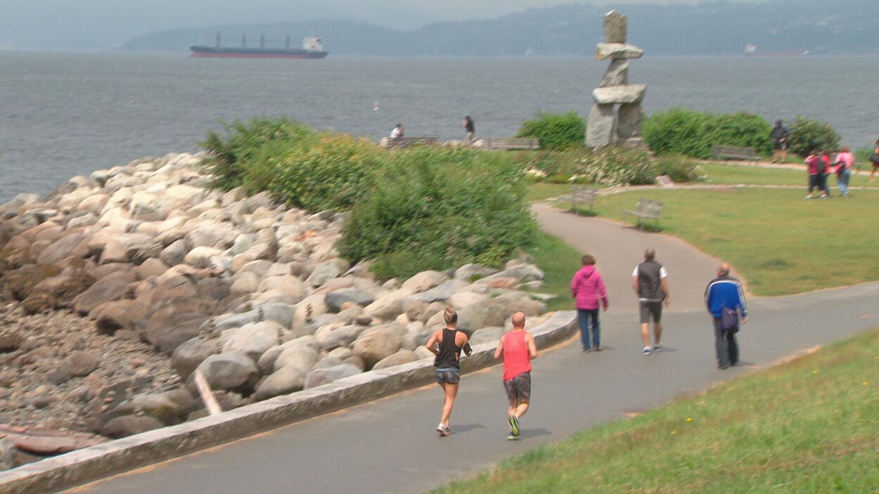 Des coureurs et des marcheurs sur la promenade de bord de mer à Vancouver.
