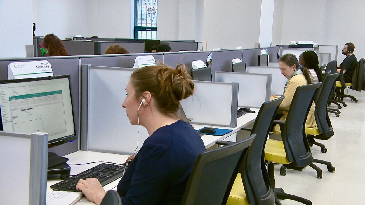 Des personnes assises dans des bureaux en train de travailler.