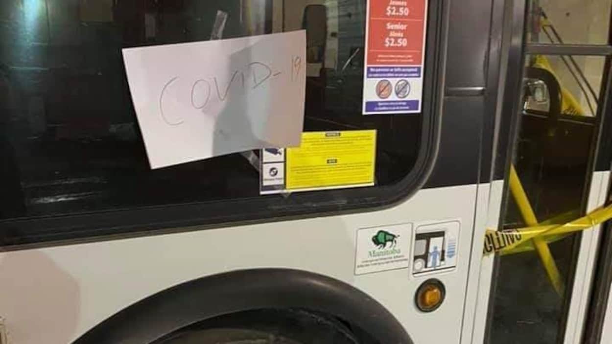 Un autobus avec une note collée sur la fenêtre sur laquelle il est écrit COVID-19.
