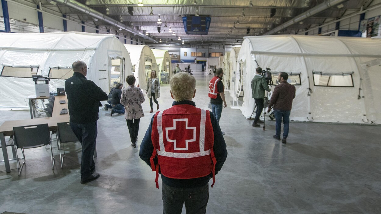 Plusieurs tentes et personnes dans un hall d’aréna