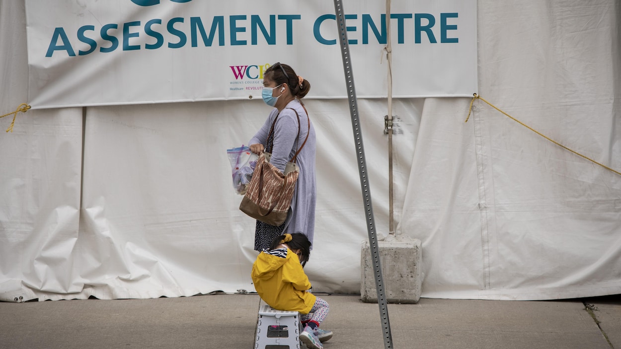 Une femme et son enfant attendent à un centre de dépistage de Toronto.