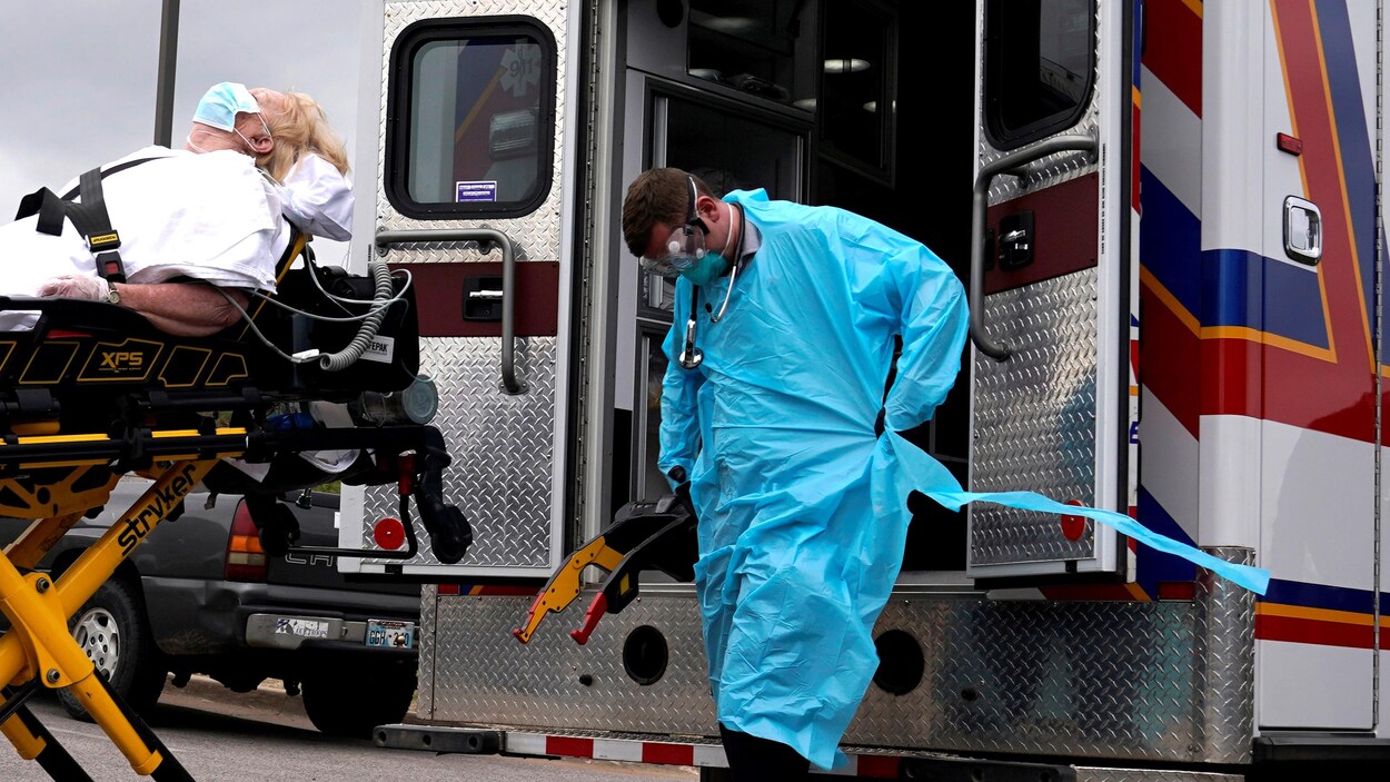 Des ambulanciers américains s’apprêtent à transporter un patient potentiellement atteint de la COVID-19.