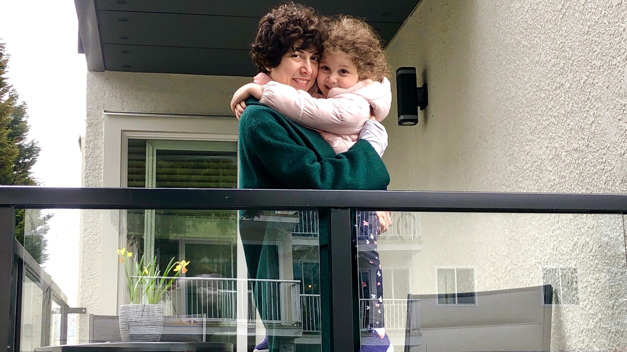 Ghinwa Yassine et sa fille Gia s'enlacent, debout sur leur balcon.