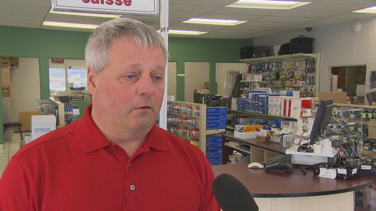 Un homme interviewé dans un magasin d'informatique.