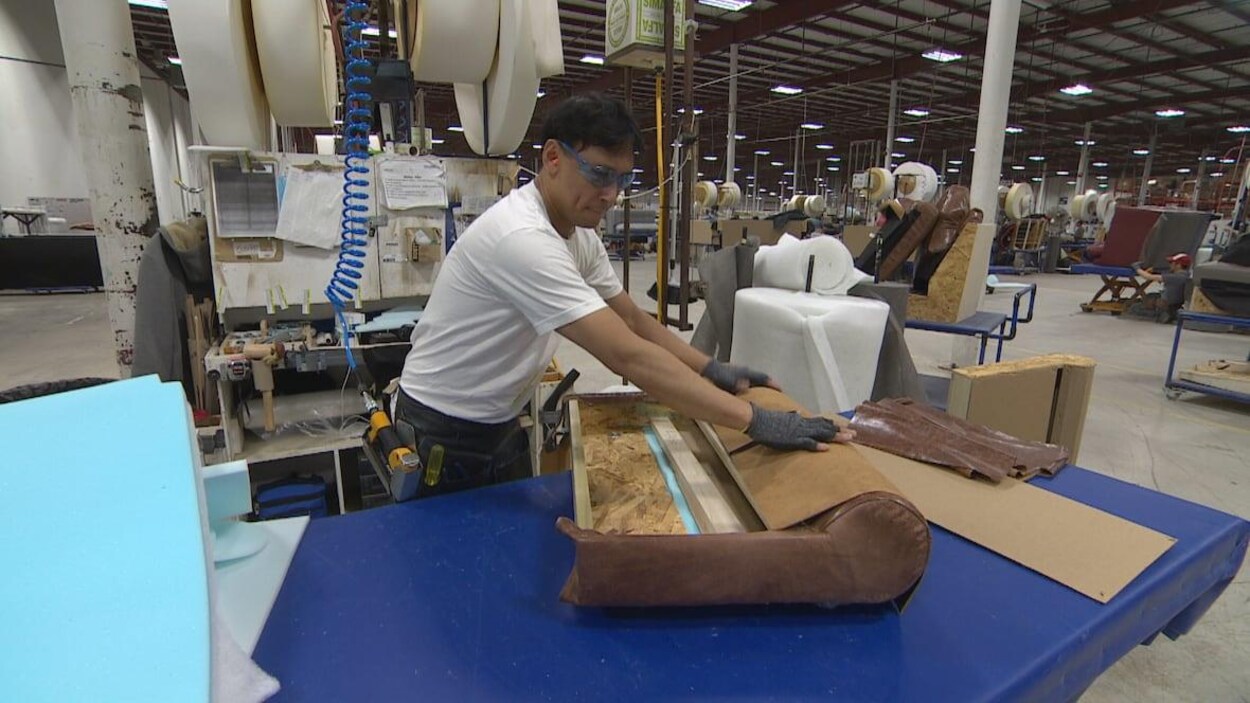 Un employé est au travail dans une usine qui fabrique des meubles.