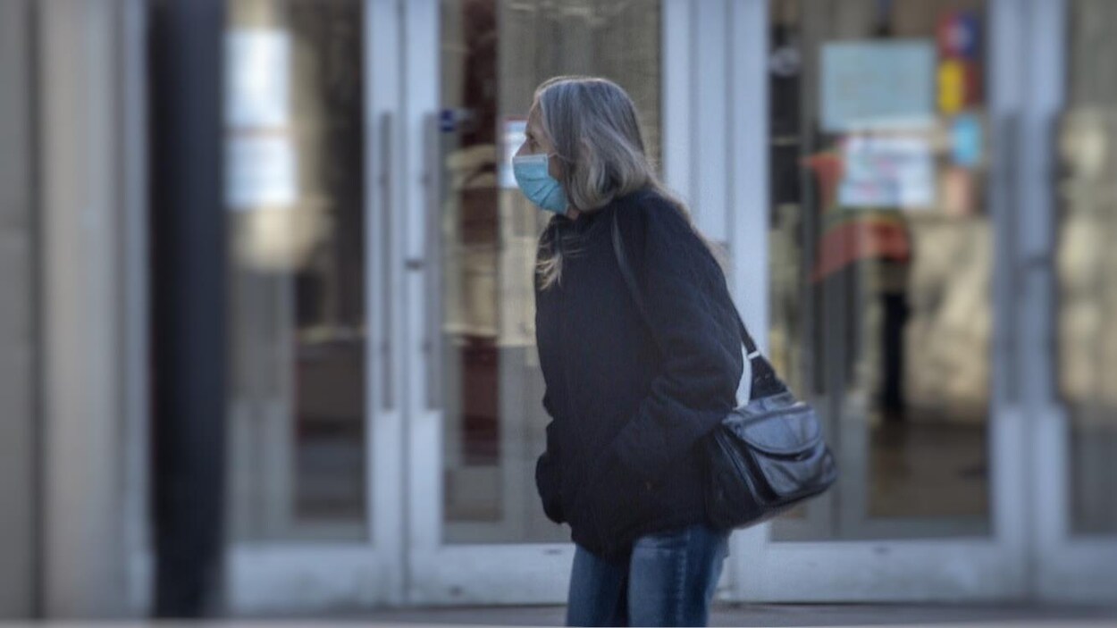 Une personne à l'extérieur avec un masque au visage.