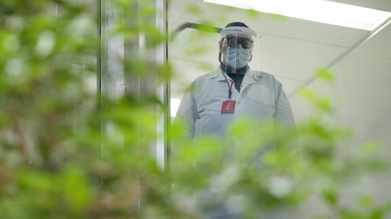 Un employé de la santé portant un masque et une visière.