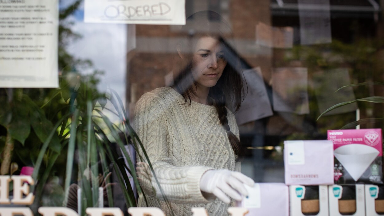 La propriétaire du magasin "The Federal", Colette Griffiths, place des produits contre la vitrine.