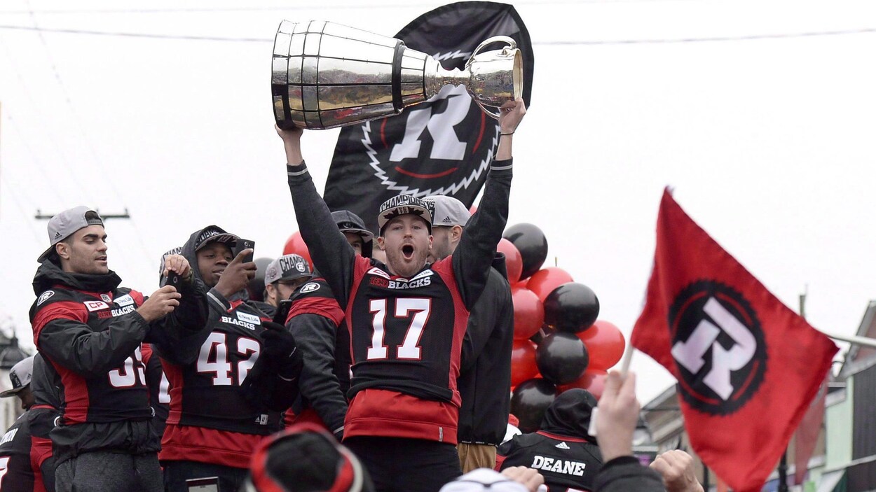 Ronnie Pfeffer du Rouge et Noir soulève la coupe Grey lors de la parade des champions, à Ottawa, le 29 novembre 2016. Ronnie Pfeffer du Rouge et Noir soulève la coupe Grey lors de la parade des champions, à Ottawa, le 29 novembre 2016.