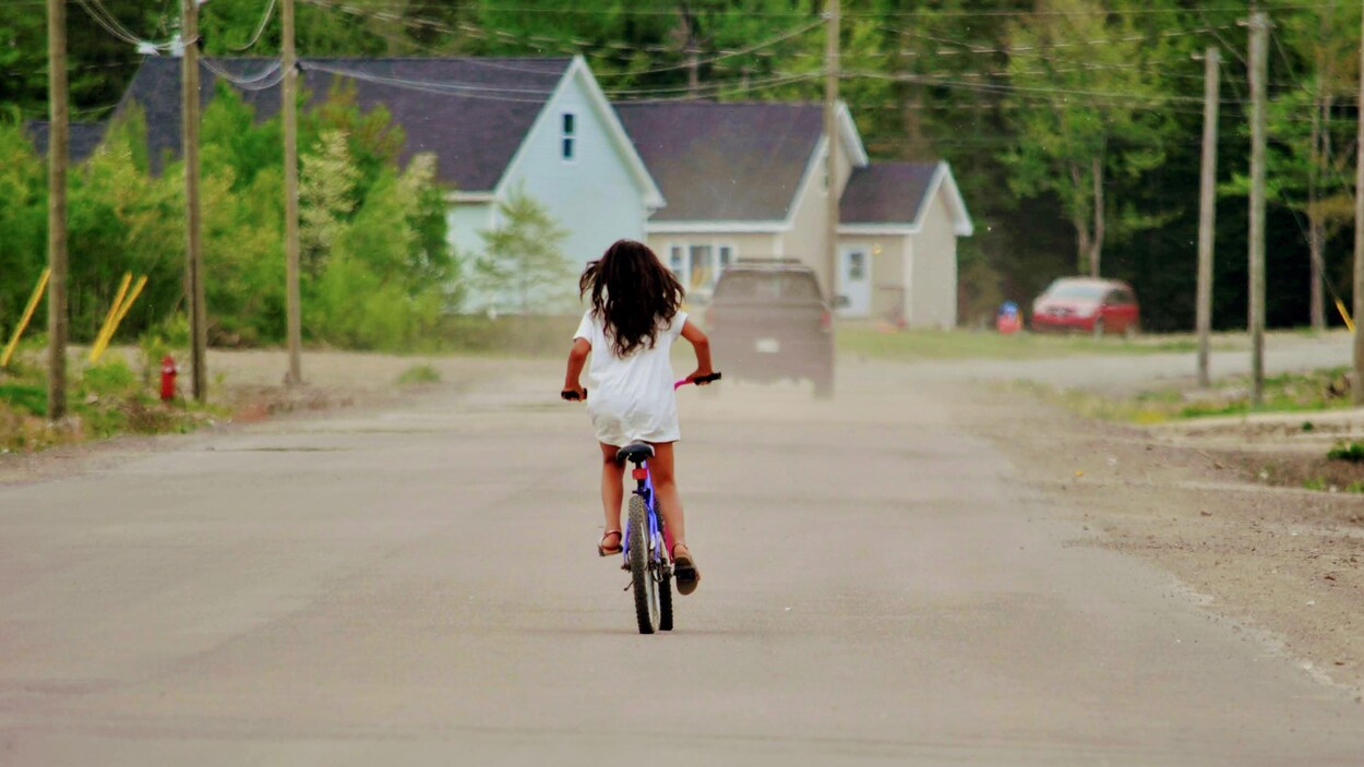 Une enfant circule à vélo dans une réserve autochtone.