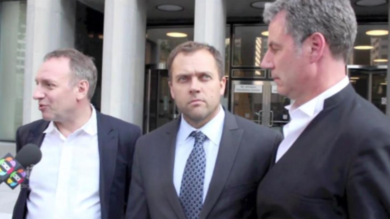 Une photo de trois hommes sortant d'un tribunal Une photo de trois hommes sortant d'un tribunal