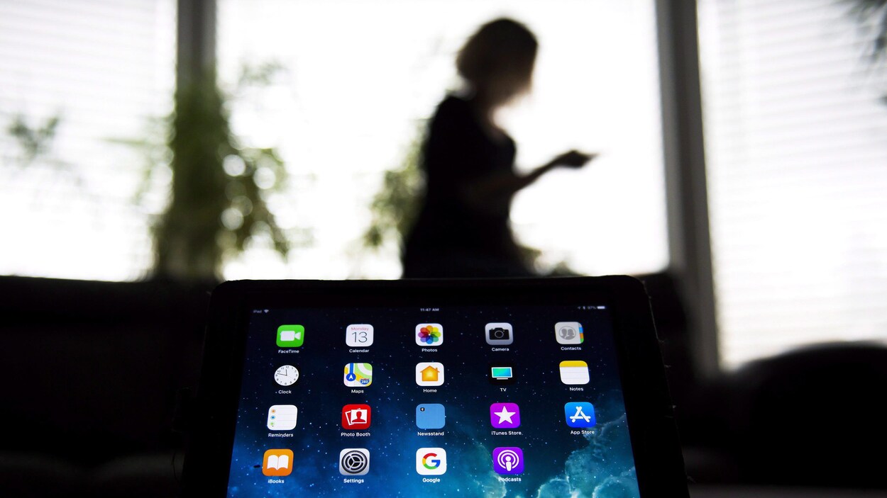 Une femme en arrière plan et un appareil électroniques avec des applications