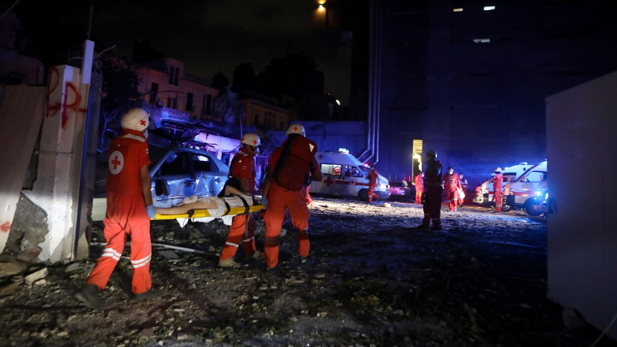Trois secouristes transportent la femme sur une civière.