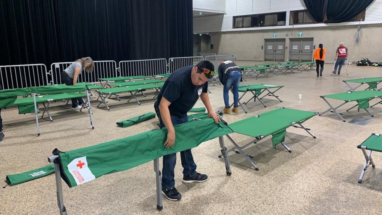 Des bénévoles installent des lits de camp dans le Centre des congrès RBC de Winnipeg.