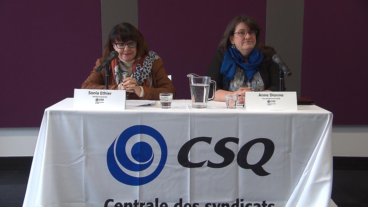 Deux femmes assises à une table s'adressent aux journalistes.