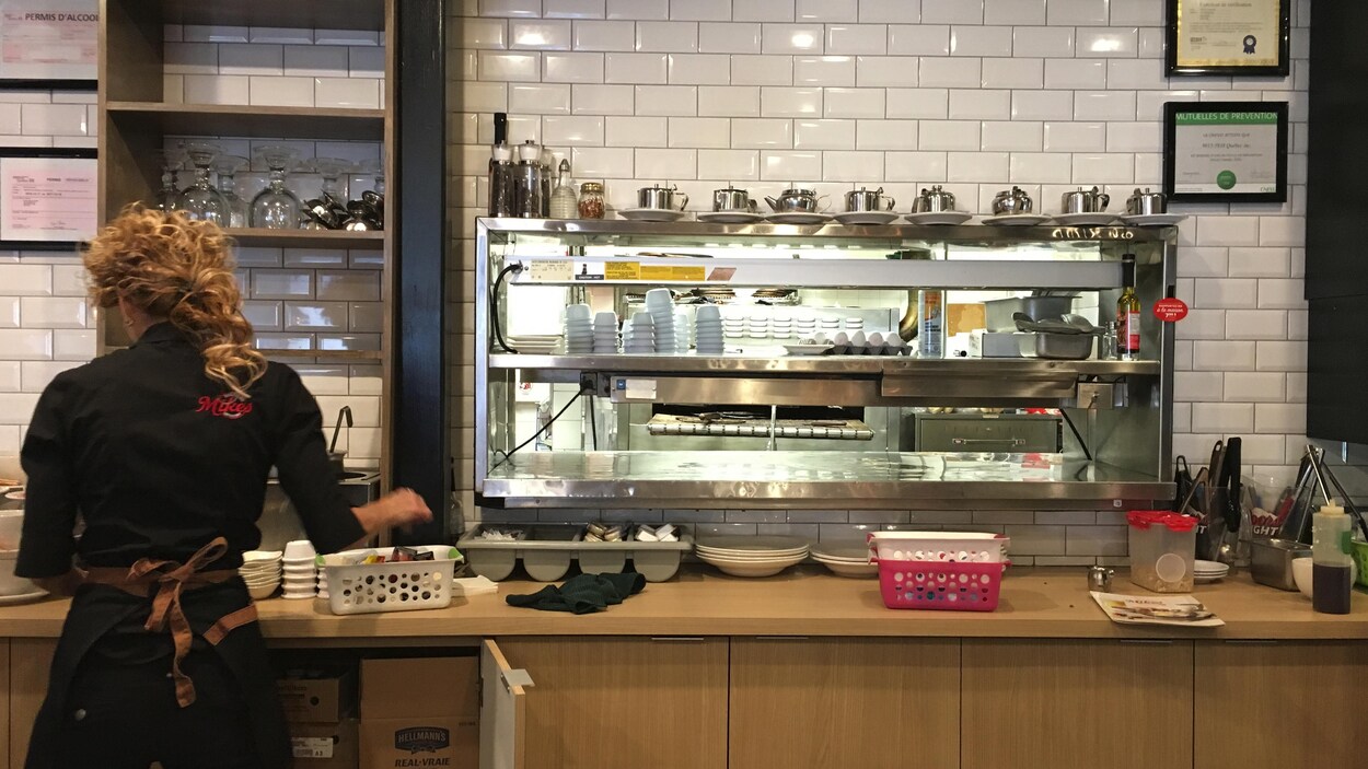 Une serveuse de dos dans la cuisine Une serveuse de dos dans la cuisine