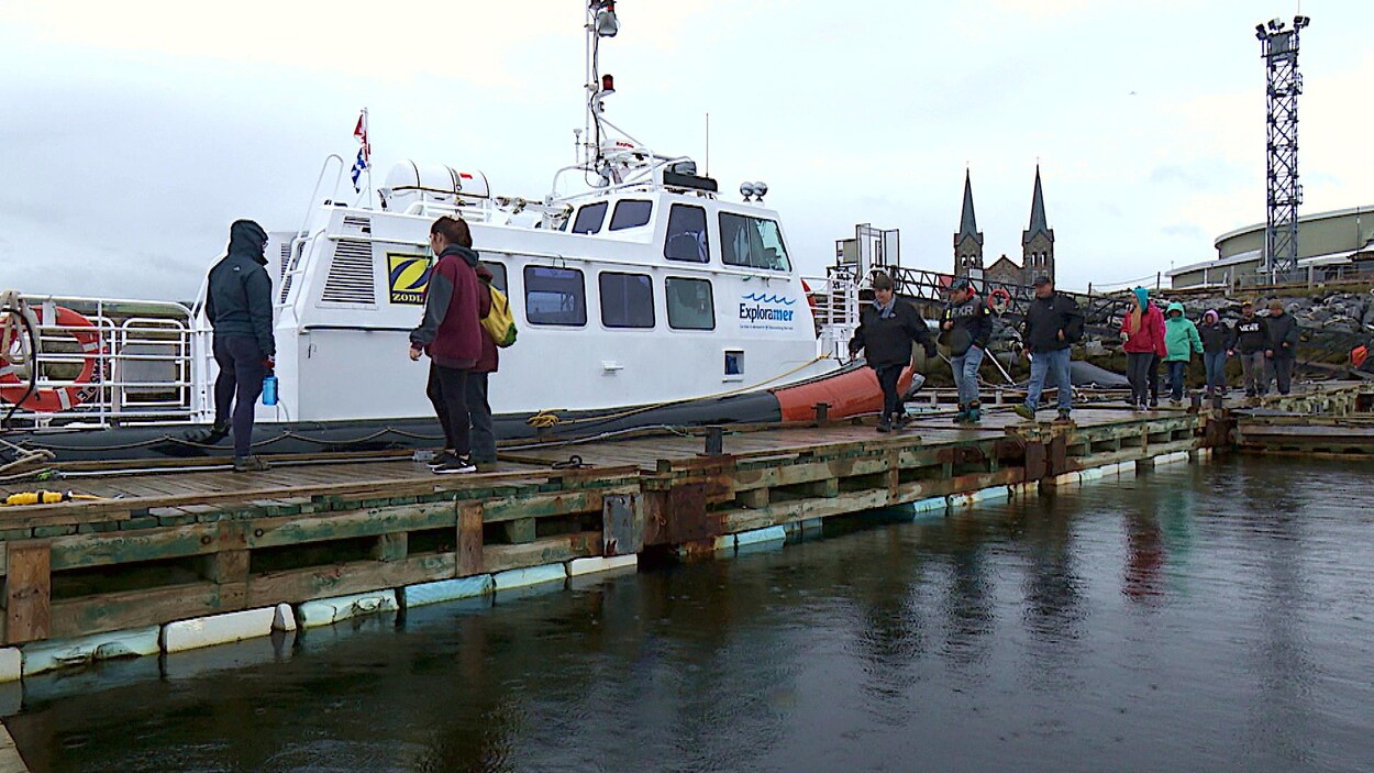 Des personnes qui embarquent à bord d'un bateau.