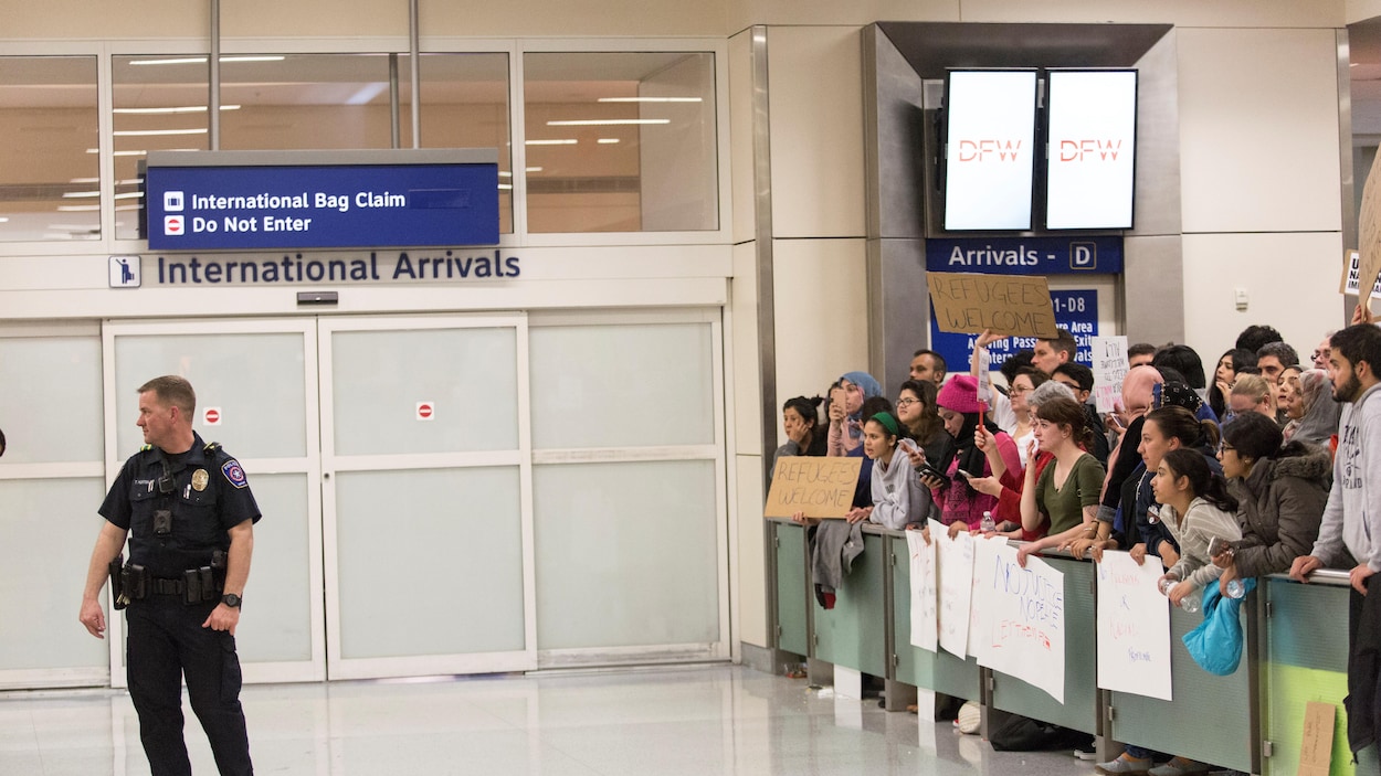 Des manifestants rassemblés pour protester contre le décret imposé par le président des États-Unis, Donald Trump à l'aéroport international de Dallas/Fort Worth. Des manifestants rassemblés pour protester contre le décret imposé par le président des États-Unis, Donald Trump à l'aéroport international de Dallas/Fort Worth.