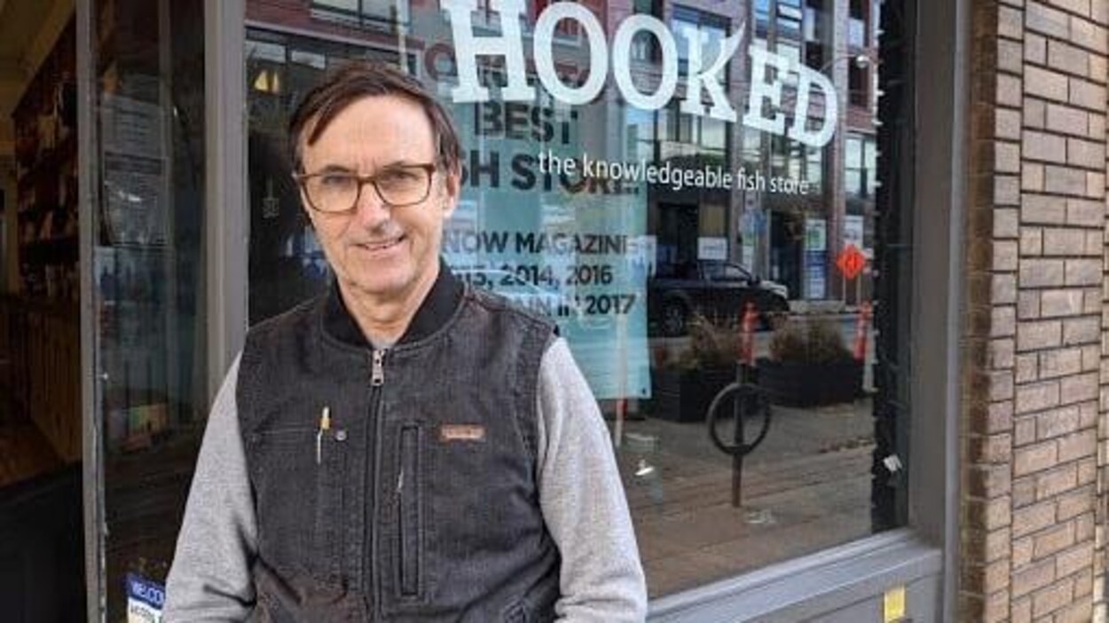 Le portrait d'un homme devant la façade d'un magasin